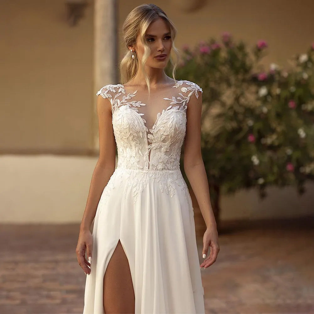 Close-up of the delicate lace cap sleeves and illusion V-neckline on a boho-inspired chiffon wedding gown.