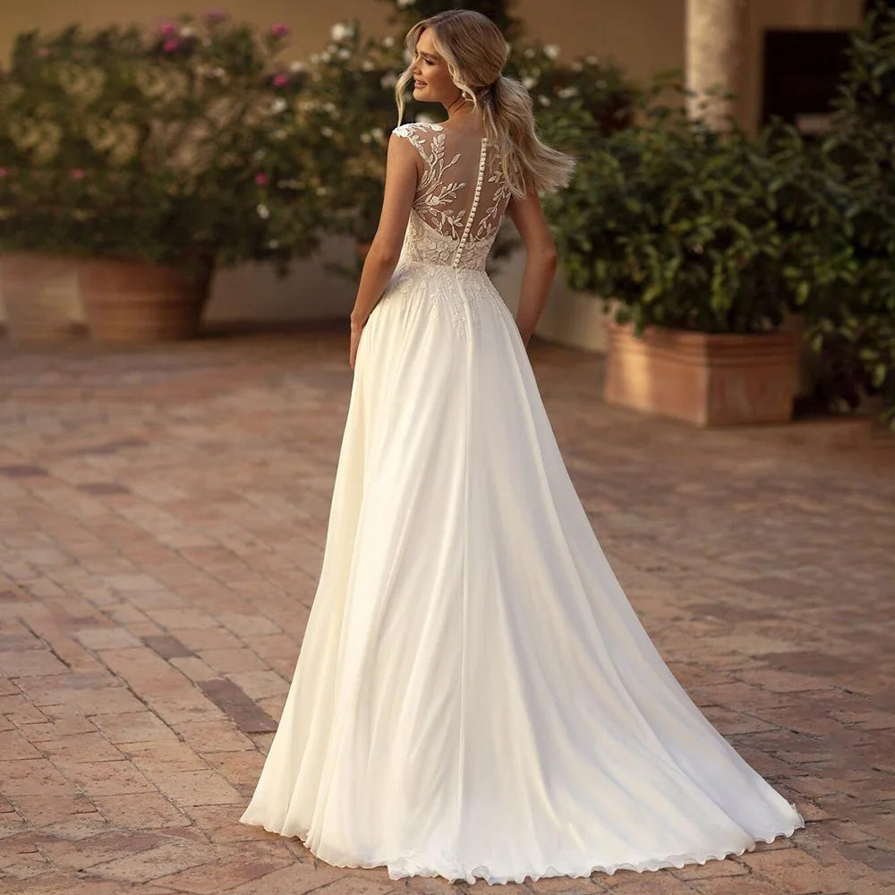 Elegant lace cap sleeve detail on a boho wedding gown with a sexy illusion neckline.