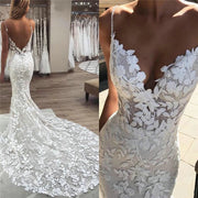 A bride wearing a boho-style mermaid wedding dress with intricate floral lace appliqués, delicate spaghetti straps, and a stunning backless design.