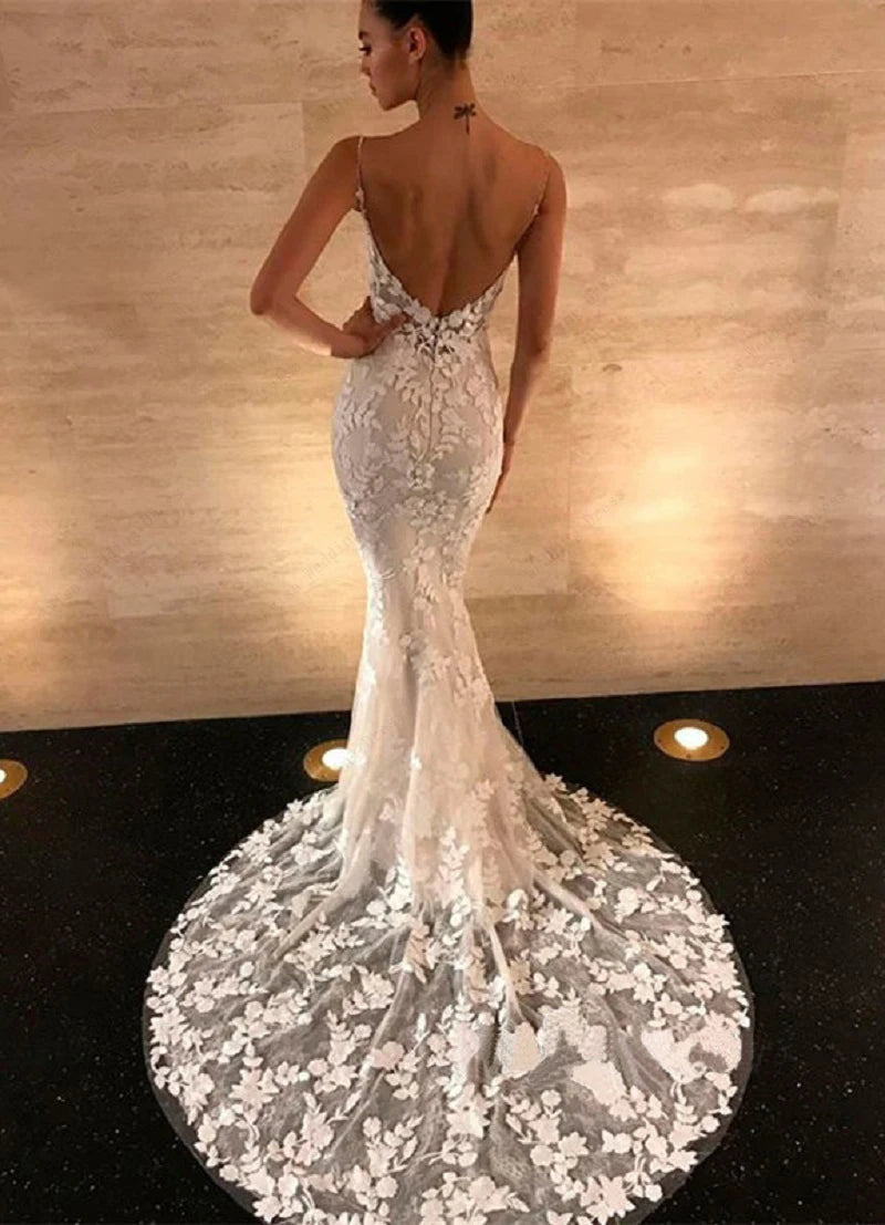 Rear view of a boho lace mermaid wedding dress, emphasizing the open, backless design and ornate lace train.