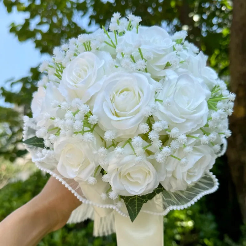Close-up view of a premium artificial bridal bouquet showcasing crisp white silk roses and delicate clusters of faux baby's breath.