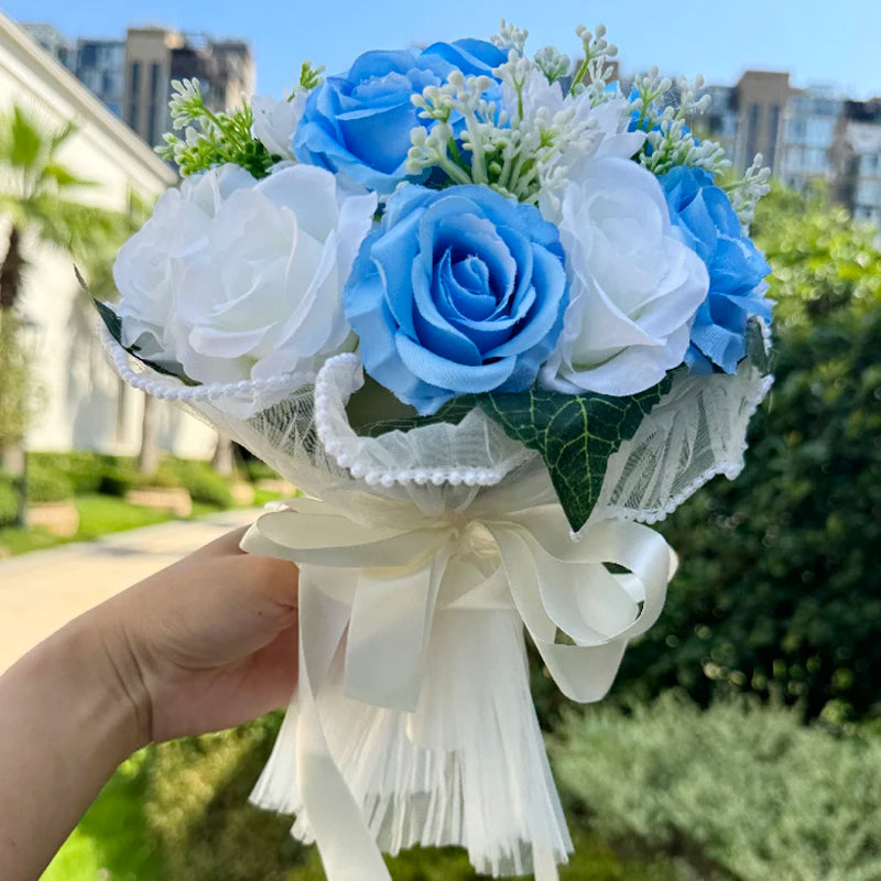 Bright summer wedding bouquet composed of vibrant sky blue and clean white silk roses accented with small white flowers.