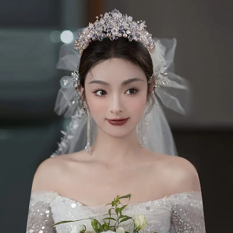 Beautiful bride wearing an elegant crystal and pearl wedding tiara with bridal veil