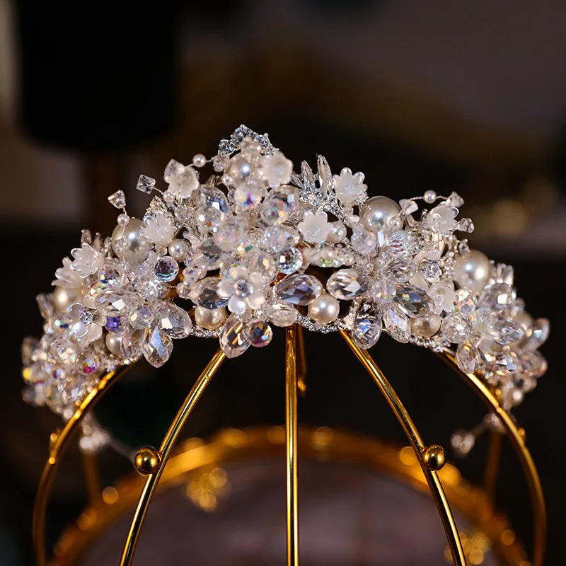 Exquisite crystal pearl wedding crown displayed on a decorative gold stand
