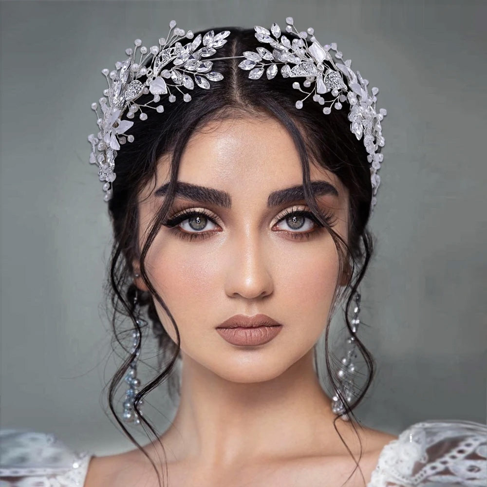 Front portrait of a bride wearing an elegant silver bridal flower headband encrusted with marquise crystals and delicate beaded sprigs.