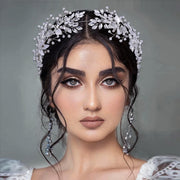 Front portrait of a bride wearing an elegant silver bridal flower headband encrusted with marquise crystals and delicate beaded sprigs.