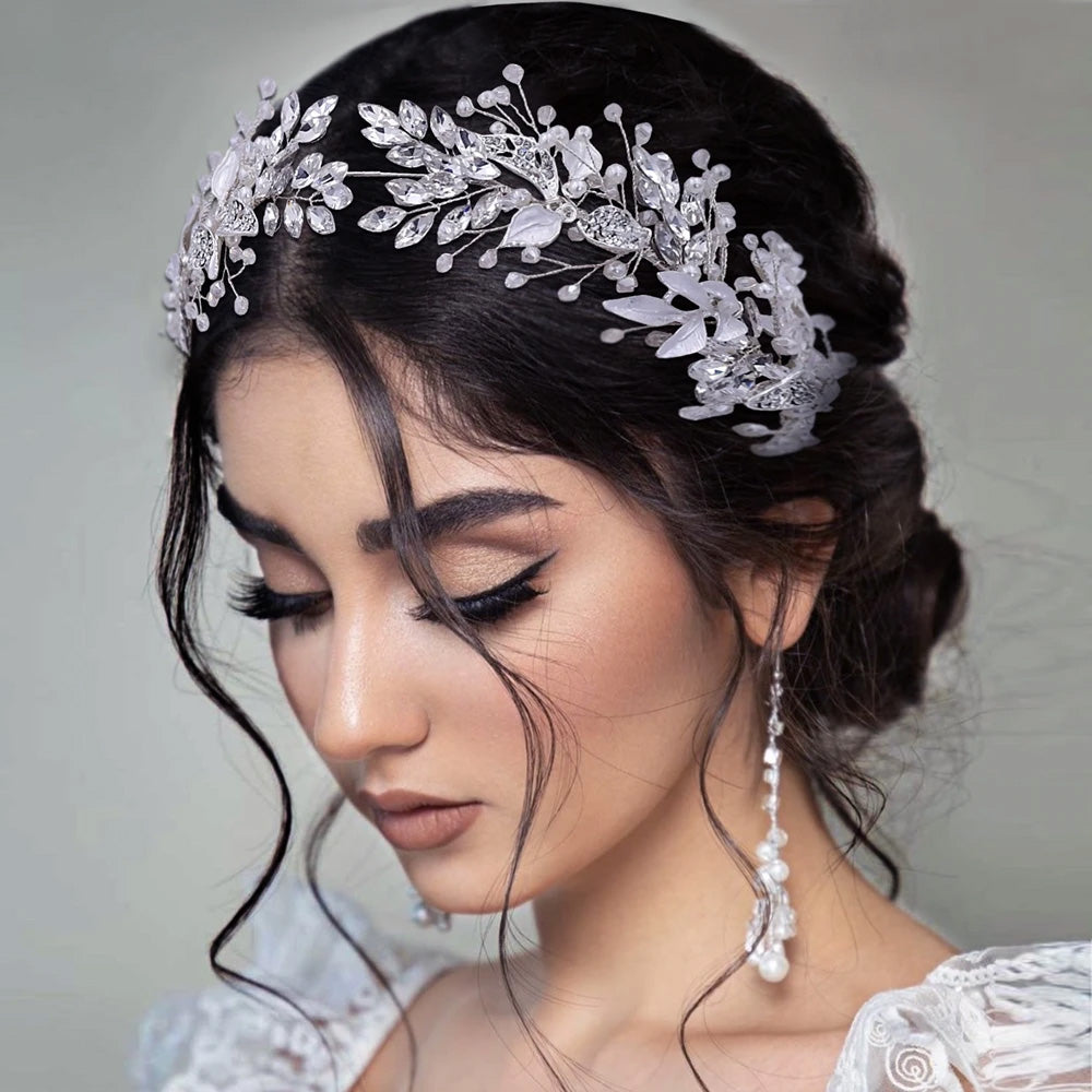 Side profile view of a brunette bride looking down, showcasing an intricate crystal wedding tiara headband with frosted glass floral leaves.