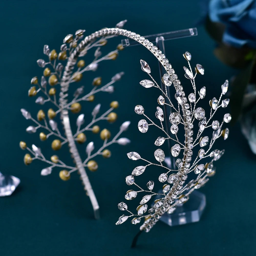Side-angle view of a silver bridal flower headband with marquise-cut rhinestones and intricate wire branch sprays on a clear display stand.
