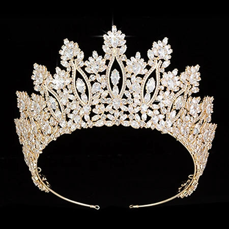A side-angle view of a sparkling crystal bridal crown resting on a black surface.