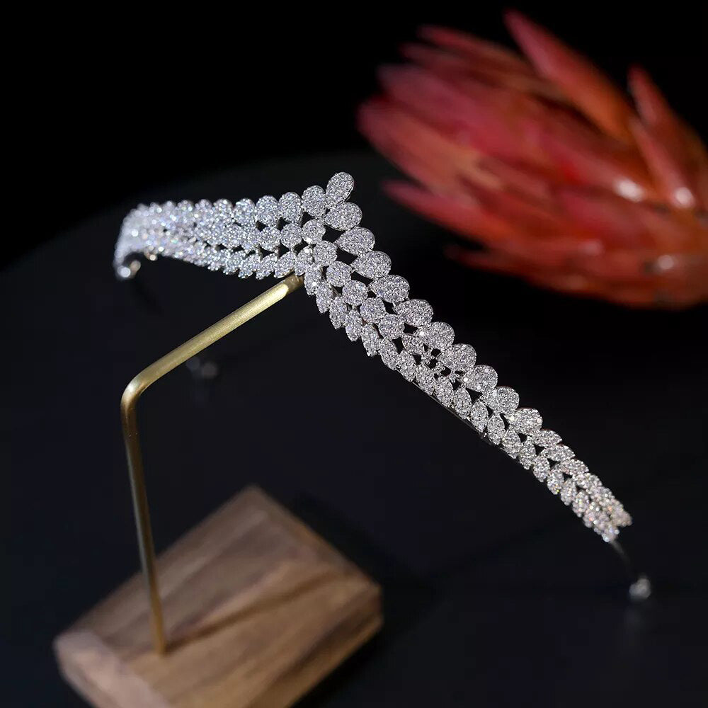 High-angle profile shot of an open-backed silver bridal hair tiara showing the curved structural frame and brilliant light-refracting crystal pavé settings.