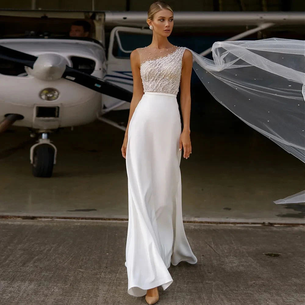 A bride wearing a stunning chiffon wedding dress with an intricate beaded lace bodice, a flowing A-line skirt, and an ethereal veil in front of a small airplane.