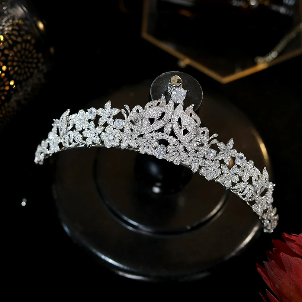 Elegant silver crystal butterfly princess crown displayed on a classic black velvet jewelry stand.