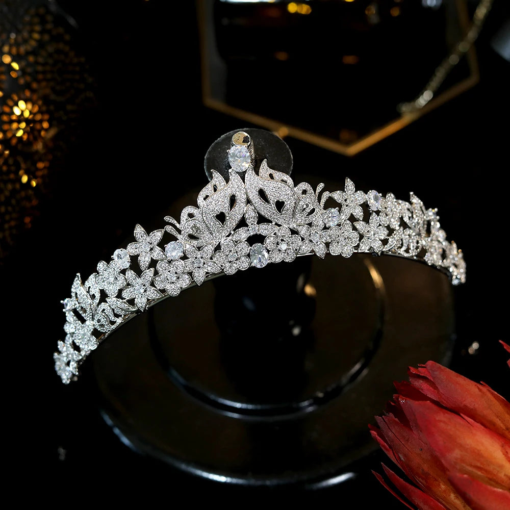Close-up shot showing the intricate floral and pave butterfly wing crystal details of a bridal headpiece.