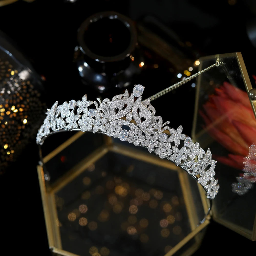 Premium cubic zirconia butterfly bridal tiara showcased above a luxury gold geometric jewelry box.