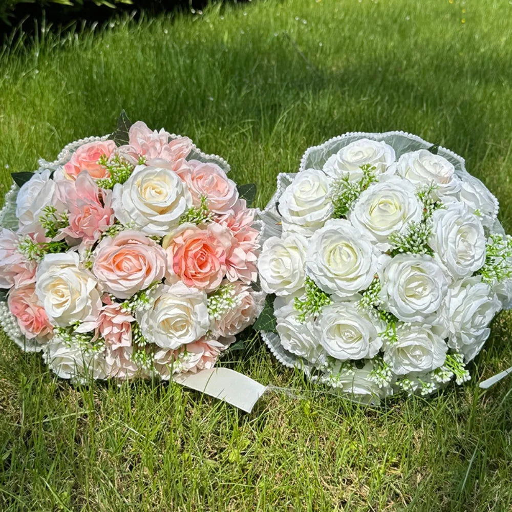 Two handmade artificial wedding bouquets—one in shades of pink and white, the other pure white—resting side-by-side on green grass.