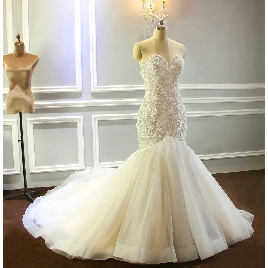 Frontal view of the fully beaded shiny champagne wedding dress on a mannequin, highlighting the intricate geometric crystal patterns and structured sweetheart bodice.
