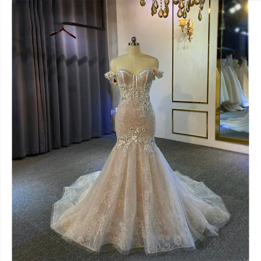 Front view of a champagne mermaid wedding dress on a mannequin, showcasing the fit-and-flare silhouette and detailed floral embroidery.