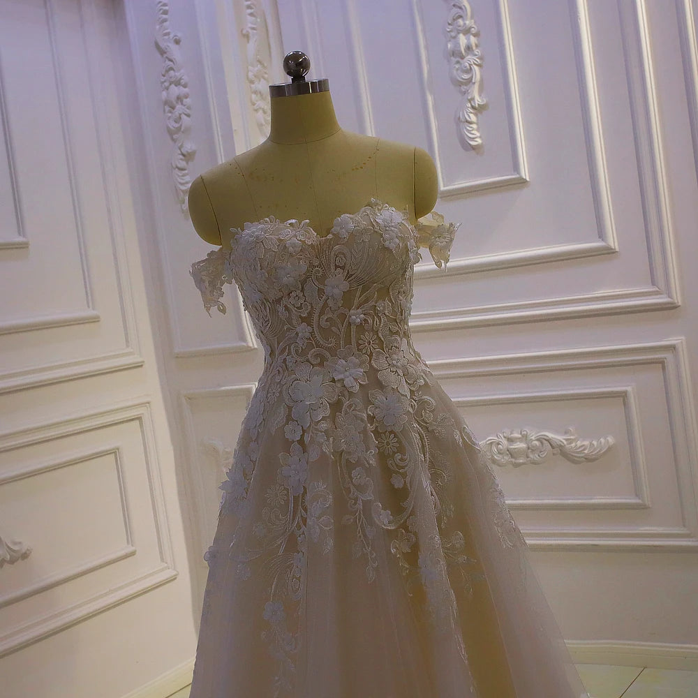 Close-up detail of a bridal gown bodice featuring 3D floral lace appliqués, a sweetheart neckline, and dainty off-the-shoulder straps.