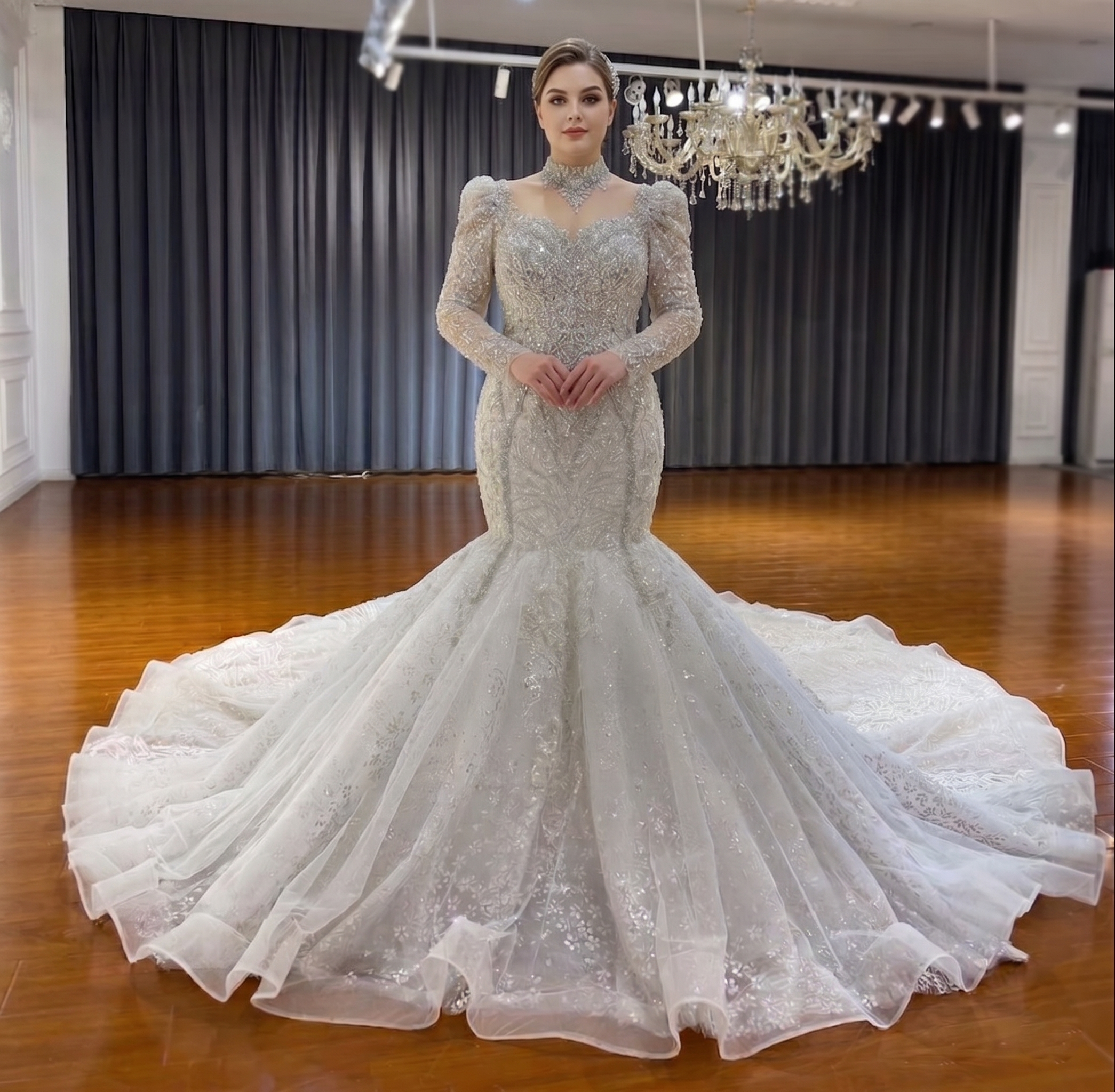 Elegant front view of a plus-size luxury mermaid wedding dress on a model, highlighting the crystal embellishments, long sleeves, and dramatic flowing train.