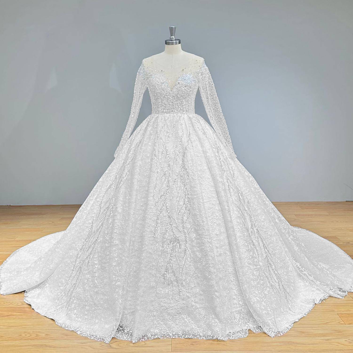 Wide front view of a luxurious crystal beaded shining ball gown wedding dress on a mannequin, emphasizing the brilliant, all-over shimmer and elegant illusion long sleeves.