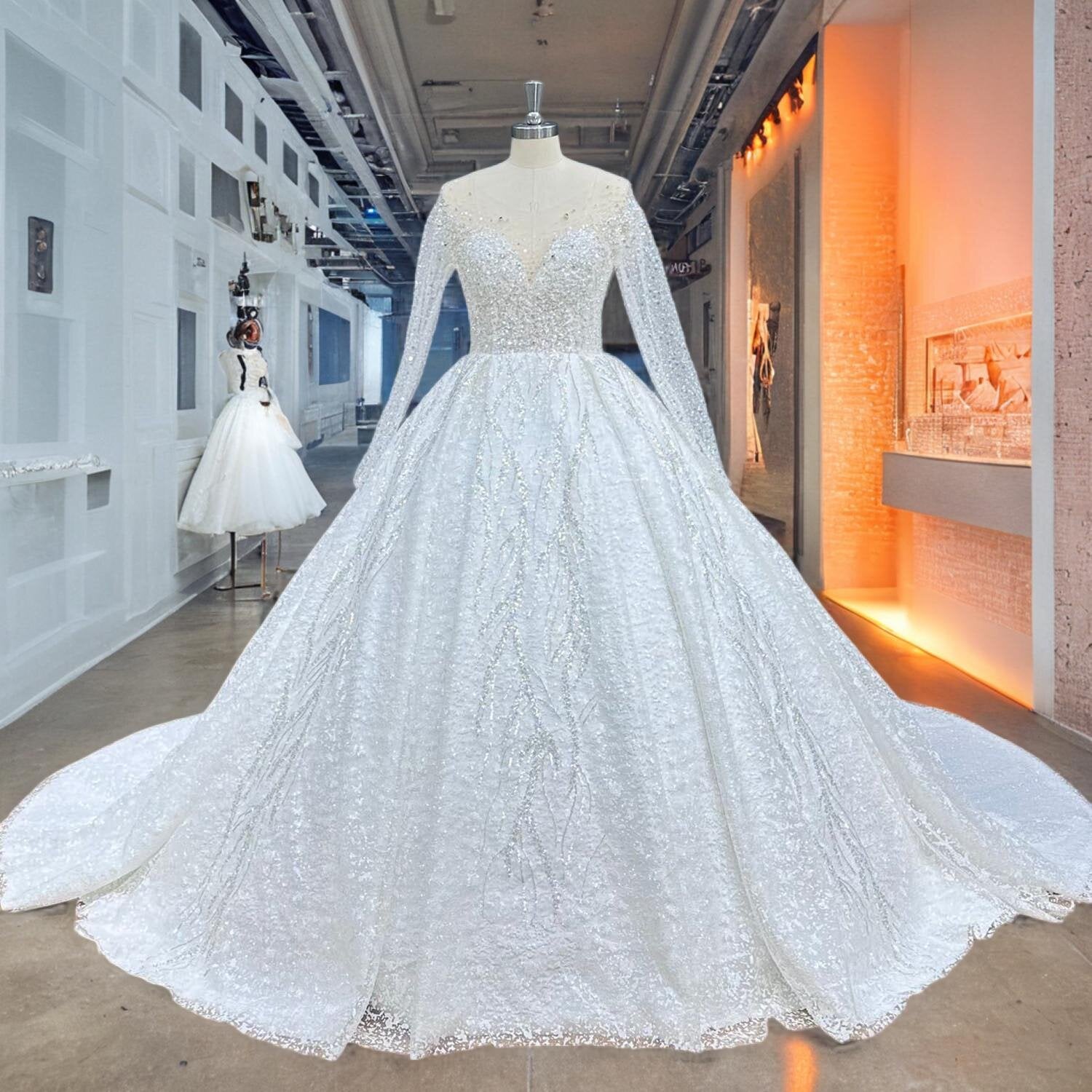 Full front view of a crystal beaded shining ball gown wedding dress on a mannequin in a bright hallway, showcasing the intricate shimmering vine patterns and sheer long sleeves.