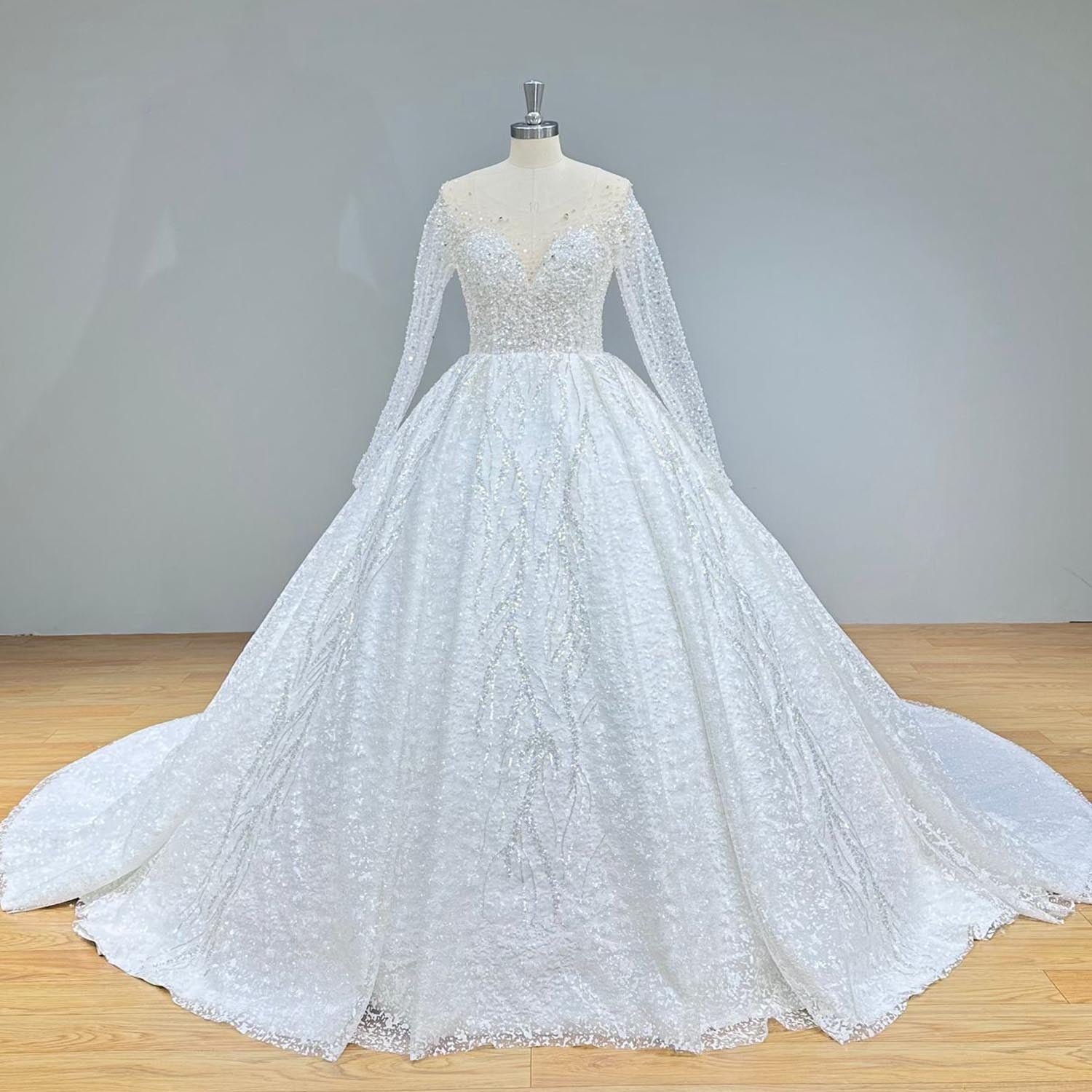 Classic full front studio view of a crystal beaded shining ball gown wedding dress on a mannequin, highlighting the voluminous, glittering skirt and tailored long sleeves.