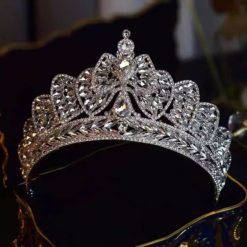 Front close-up view of a sparkling crystal bowknot bridal crown tiara with brilliant marquise rhinestones on a dark surface.