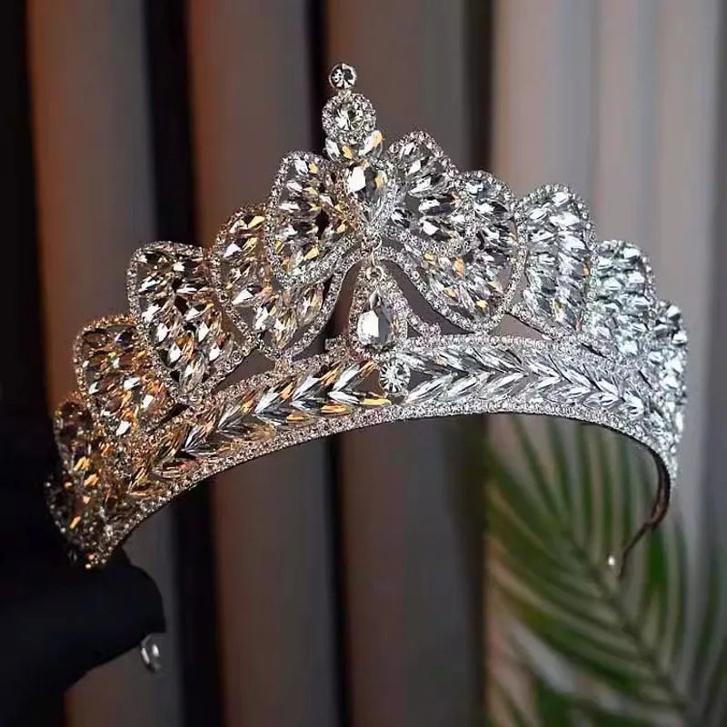 Side angle view of a glamorous crystal bowknot bridal crown tiara highlighting the patterned rhinestone leaf and bow clusters.