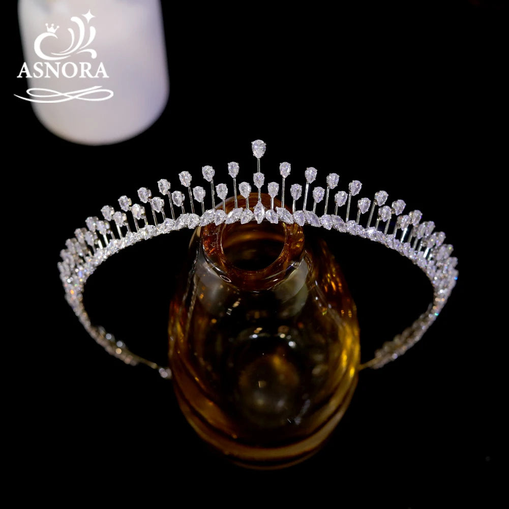 Front profile view of a high-end crystal wedding crown hair accessory resting on an amber glass stand.