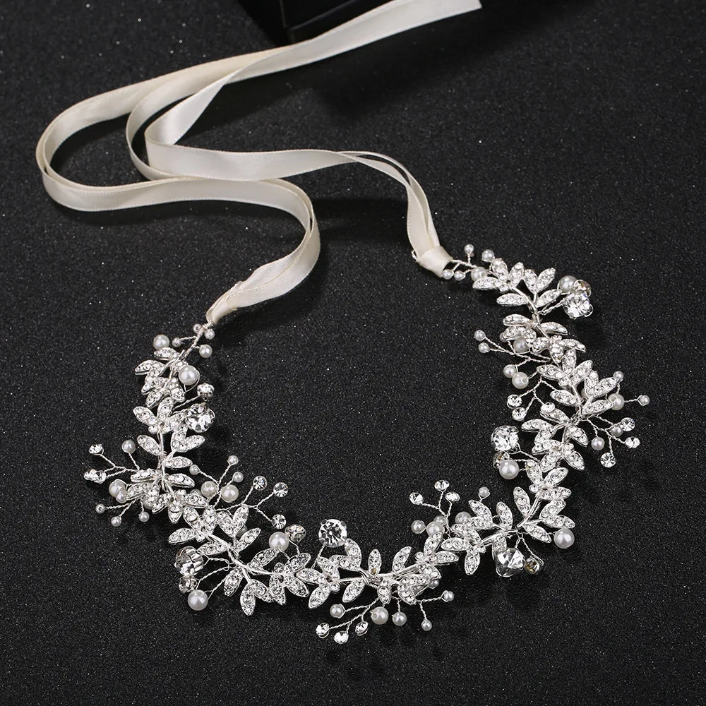 Detailed view of a silver crystal flower wedding headband with adjustable white ribbons.