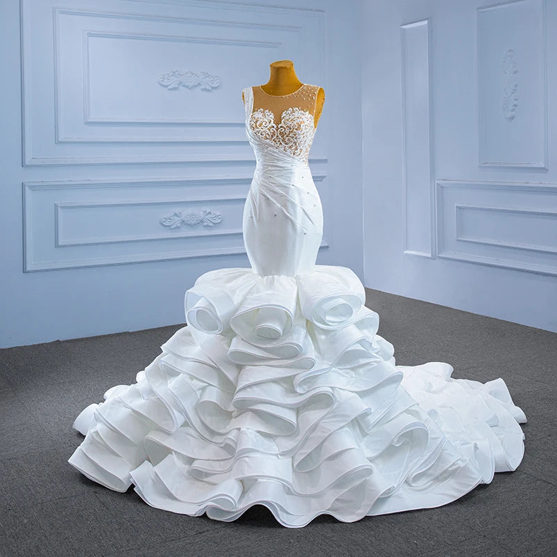 Detailed front perspective of a crystal mermaid wedding dress on a mannequin, emphasizing the structural volume of the circular ruffled satin skirt.