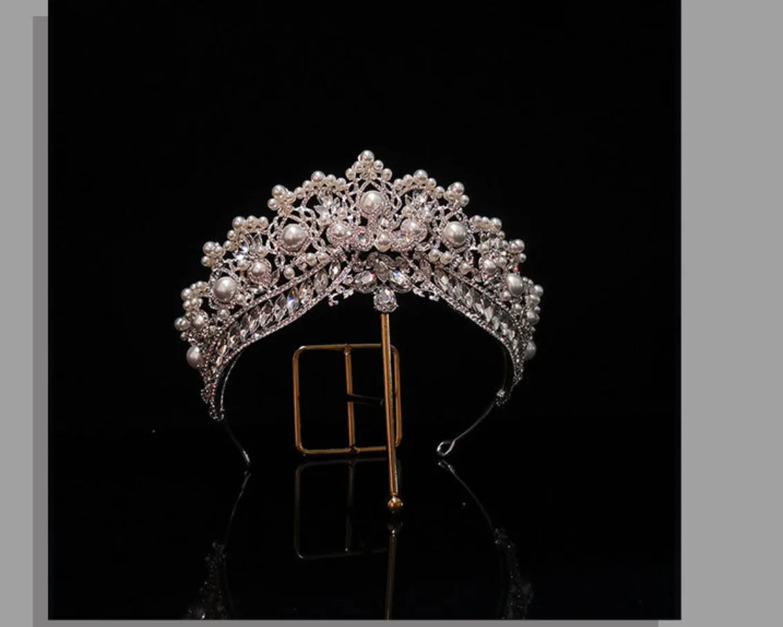 High-end queen crown for weddings featuring intricate rhinestone filigree and white pearls on a black background.