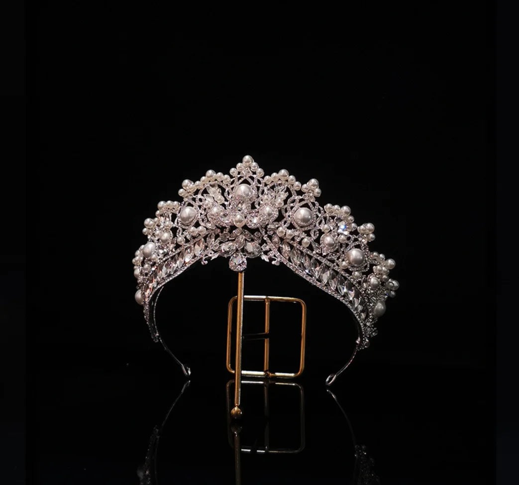 Detailed close-up of a glamorous crystal queen crown accented with luminous faux pearls for special occasions.