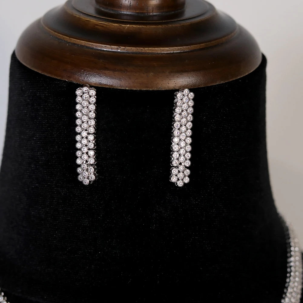 Close-up macro shot of the sophisticated multi-row cubic zirconia bridal dangle earrings displayed on a black velvet background.