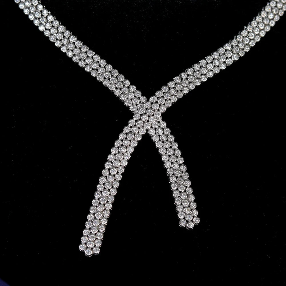 Close-up macro view of the intricate crossover accent on the sparkling silver cubic zirconia bridal tennis necklace.