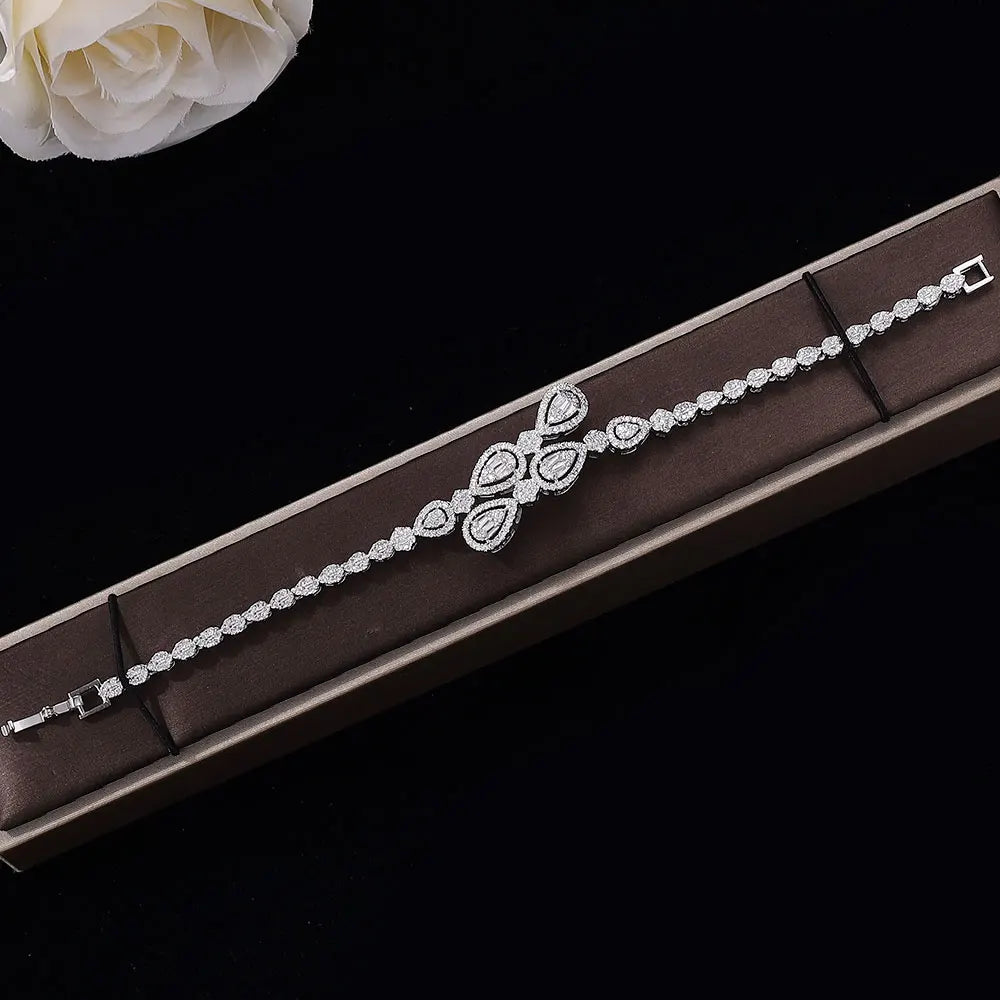 Detailed close-up shot of a silver cubic zirconia bridal tennis bracelet featuring a central marquise and teardrop crystal cluster design.