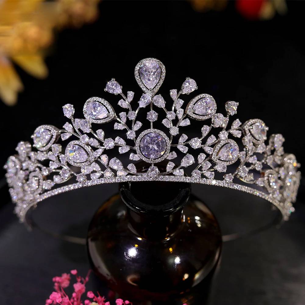Front profile of a sparkling cubic zirconia wedding crown displayed on a classic dark glass jewelry stand.