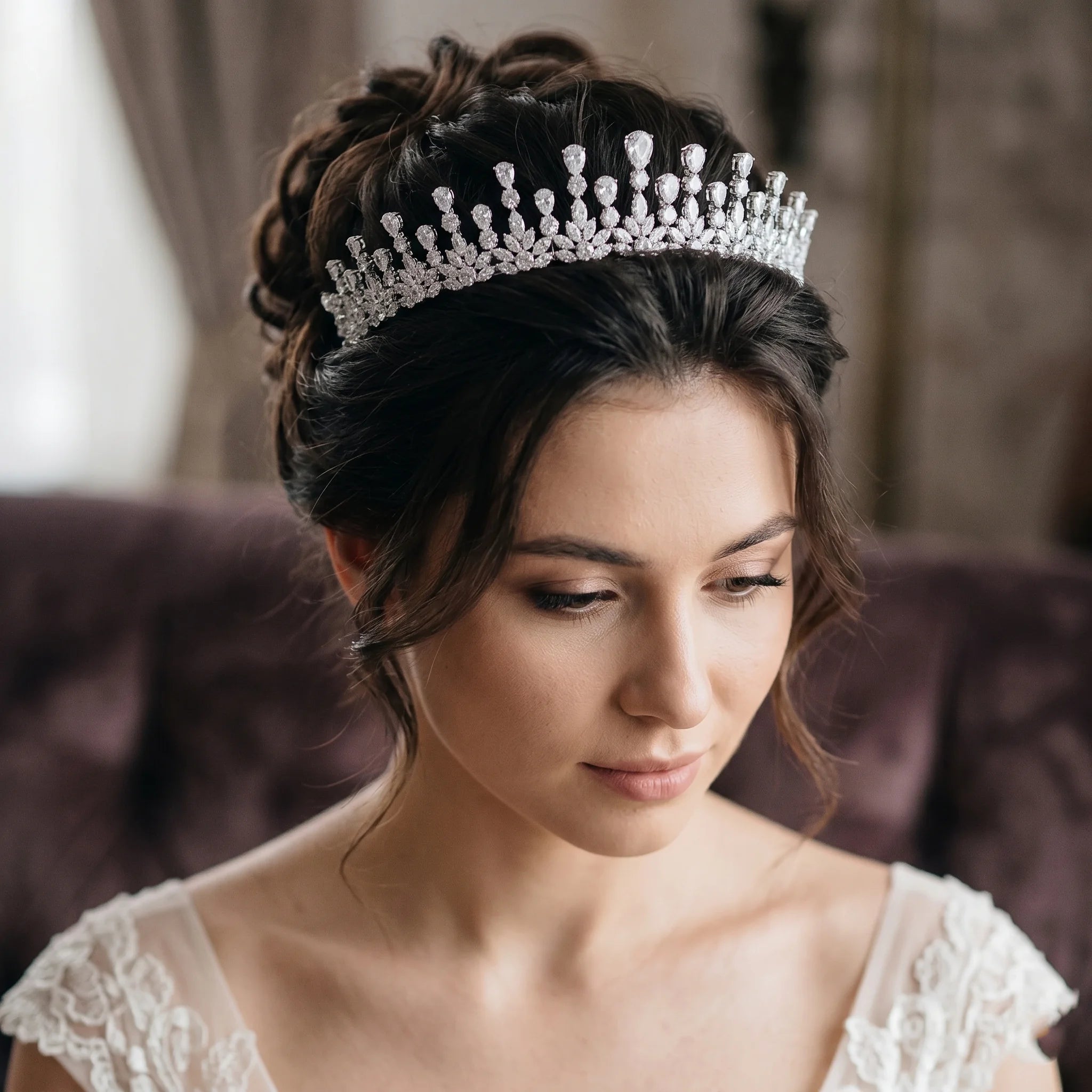 Model with elegant bridal updo wearing a cubic zirconia princess tiara headband for wedding hair styling