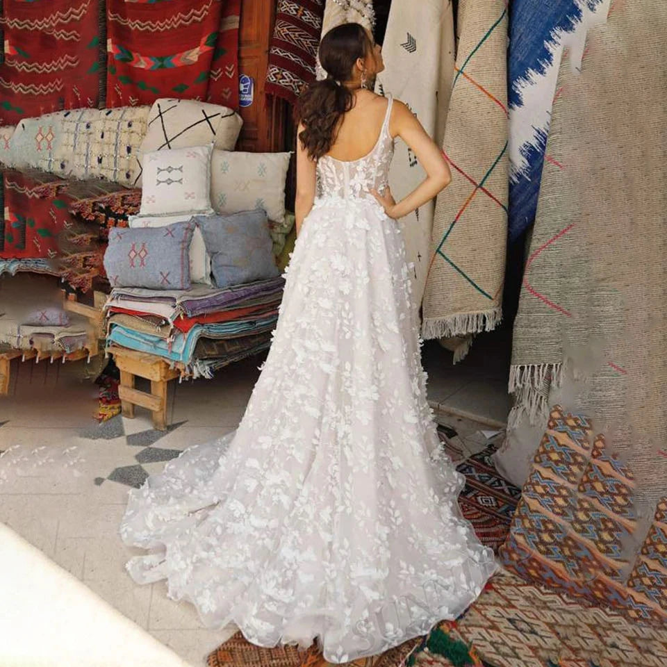 Side-profile of an elegant sleeveless bridal gown featuring delicate leaf appliques and a flowing A-line silhouette.