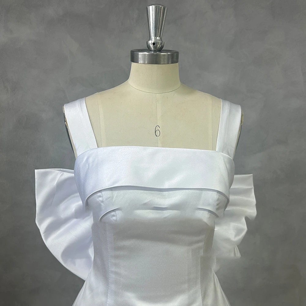 Detailed front shot of a minimalist white satin bridal bodice on a dress form, highlighting clean princess seams and a tailored square collar neckline.