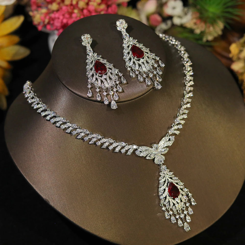Luxury wedding jewelry set featuring a silver rhinestone tassel necklace and earrings with ruby red crystal accents