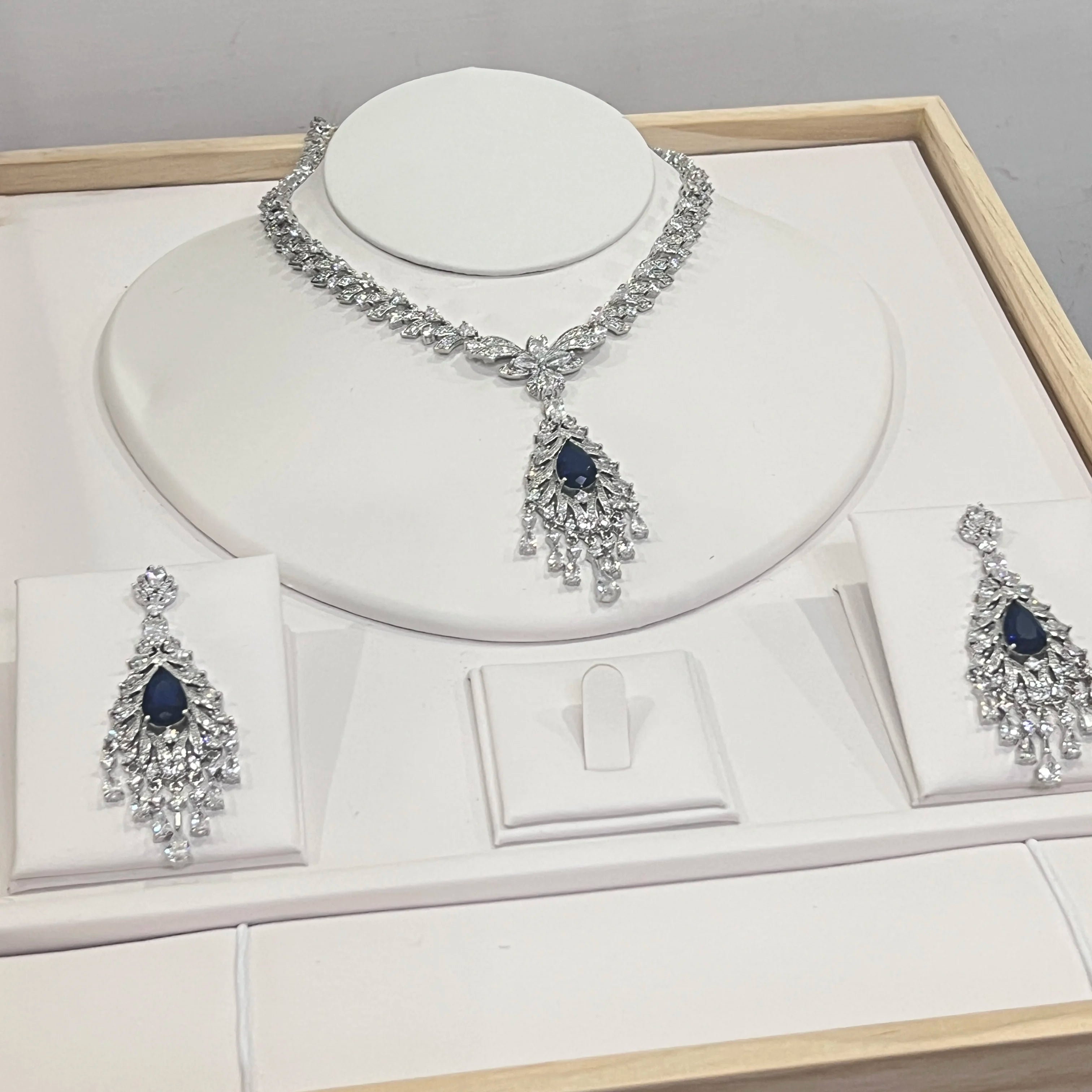 Premium sapphire blue gemstone and crystal tassel necklace set showcased on a luxury wedding jewelry display