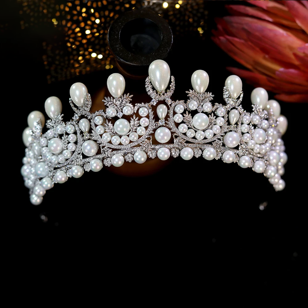 Front close-up look at the central scroll design and brilliant zircon settings of a luxury pearl crown wedding hair accessory.