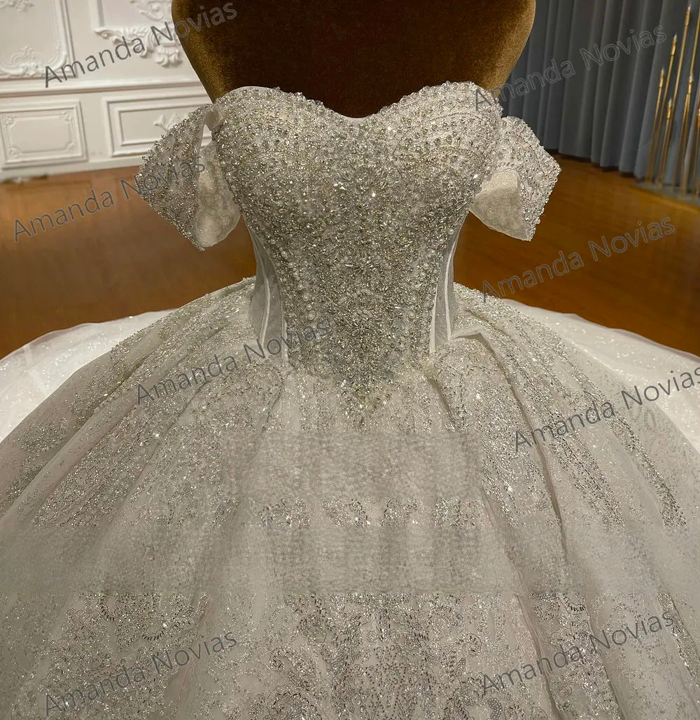 Detailed close-up of the beaded wedding dress bodice, showcasing the high-quality craftsmanship of silver crystal accents and the versatile detachable shoulder straps.