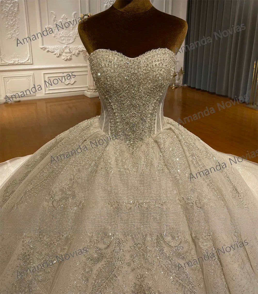 Detailed view of a strapless bridal bodice with dense silver beadwork and a sweetheart neckline, reflecting light brilliantly without the optional straps.