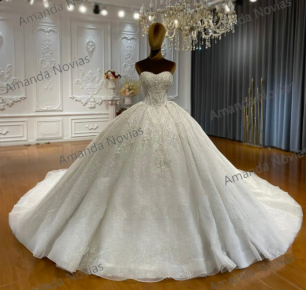 Full-length front view of the luxury strapless ball gown, demonstrating the grand ballroom silhouette and sparkling fabric for a classic sleeveless bridal look.