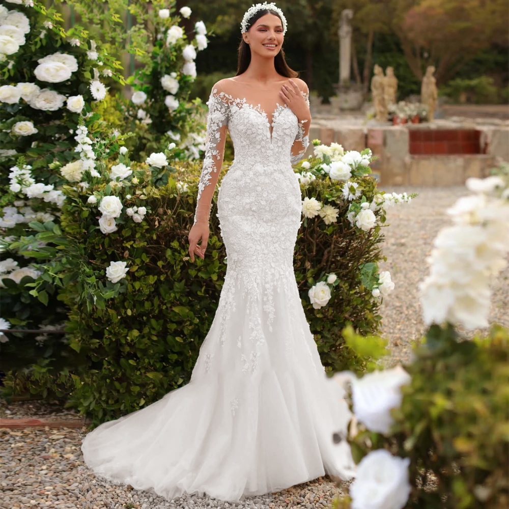 A beautiful bride standing outdoors in a white mermaid wedding dress with intricate lace appliques, full sleeves, and a long detachable train.