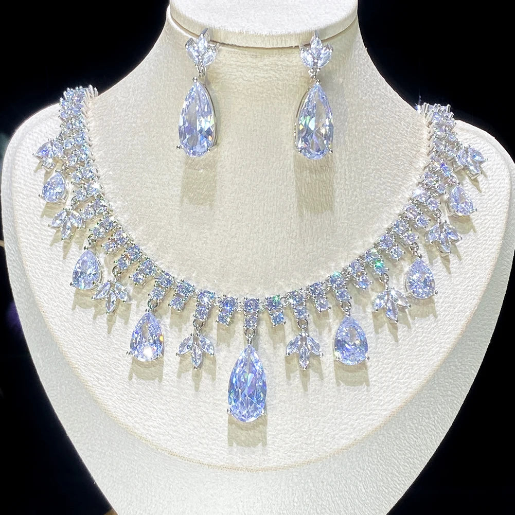 Symmetrical front close-up view of the sparkling cubic zirconia teardrop tassel necklace and matching drop earrings on a jewelry mount.