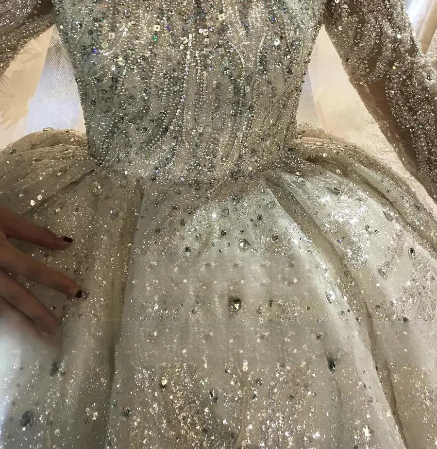 Detailed macro shot of high-end silver beading and reflective sequin craftsmanship on a luxury bridal gown fabric.