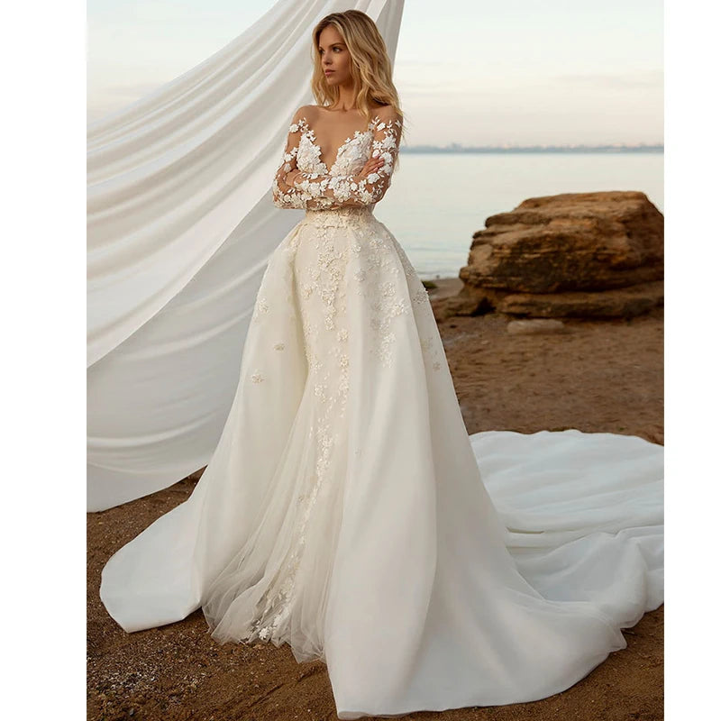 Elegant 2-in-1 lace mermaid wedding dress with detachable train, featuring long sheer floral sleeves and a deep plunging neckline.